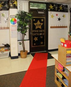 a red carpeted hallway leading to a stage door entrance with stars on the wall