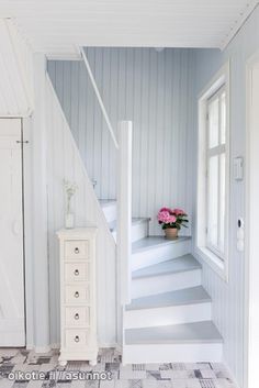 the stairs are painted white and have flowers in vases next to them on either side