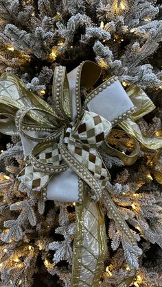 a christmas tree decorated with gold and white ribbons