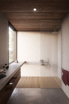 a bathroom with a wooden floor and white walls, along with a large window that looks out onto the outdoors