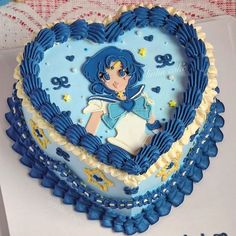 a blue heart shaped cake with sailor girl on it