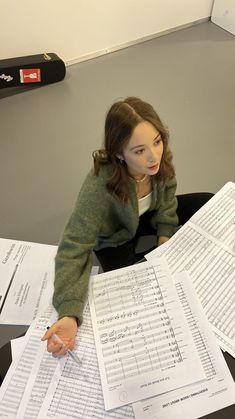 a woman sitting at a desk with lots of papers