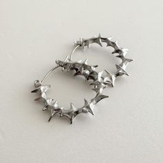 Elevate your style with these bold, spiky stainless steel hoop earrings. 100% stainless steel, 1" diameter. The modern design features small spikes that add an edgy statement to any look. Made from durable stainless steel, these earrings are lightweight and comfortable for all-day wear. Add a touch of contemporary attitude to your ensemble with these standout hoops. We ship in 1-3 days, all purchases come with complimentary jewelry pouch and box. Pretty Silver Jewelry, Earrings Edgy, Spike Hoop Earrings, Earrings Punk, Earrings Gothic, Edgy Earrings, Jewelry Gothic, Punk Earrings, Earrings Star