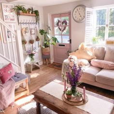 a living room filled with furniture and lots of plants on top of the coffee table