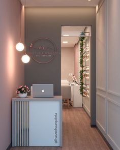 a laptop computer sitting on top of a counter in front of a wall mounted planter