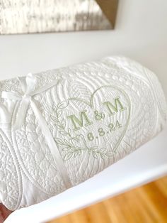 a close up of a wedding ring pillow on a wooden table with a mirror in the background