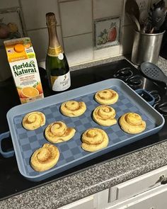 some food is sitting on a pan in the kitchen next to an orange juice bottle