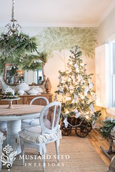 a dining room with a christmas tree in the corner and other decorations on the wall