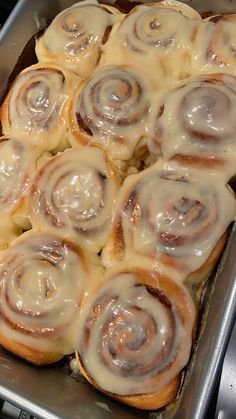 a pan filled with cinnamon rolls on top of a stove