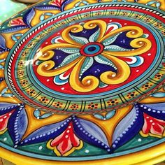 an artisticly painted plate sitting on top of a table