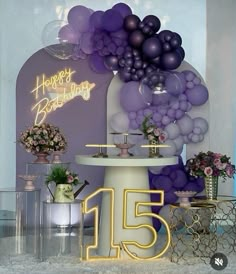 a table topped with balloons and flowers next to a sign that says happy birthday 15