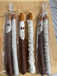 four different types of sausages wrapped in plastic on a wooden cutting board with string