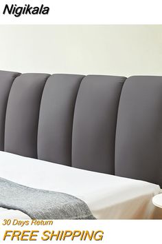 the headboard of a bed is upholstered with grey fabric