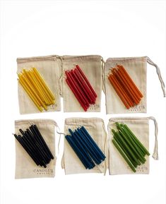 six different colored candles in small pouches