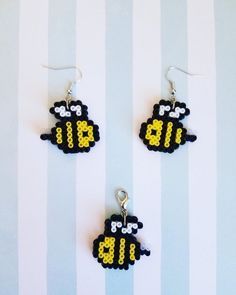 two black and white sheep earrings with yellow numbers on them, hanging from silver earwires