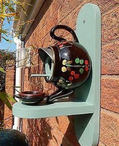 a tea pot on a shelf next to a brick wall