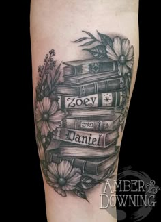 a tattoo with books and flowers on it