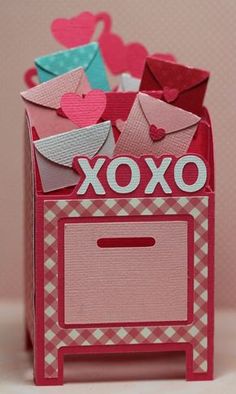 an origami box with some envelopes in it and hearts on the top