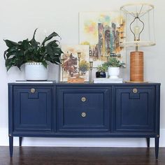 a blue sideboard with two plants on top