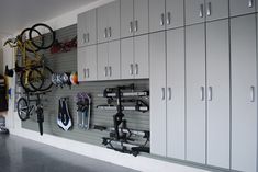 a garage filled with lots of different types of bikes and tools on the wall next to stairs