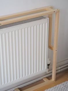 a white radiator sitting on top of a wooden floor next to a wall