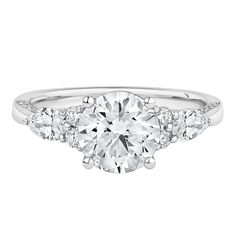 a three stone engagement ring with diamonds on the band and an oval cut diamond in the center