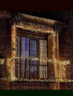 an old brick building with christmas lights on the windows