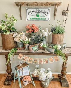 a table with flowers and plants on it in front of a sign that says flower market