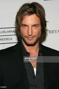 a young man in a black suit and striped shirt poses for the camera at an event