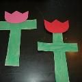 two paper flowers made to look like crosses