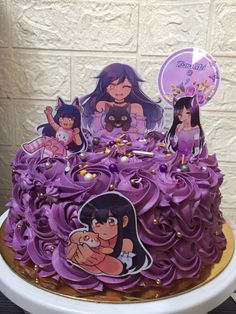 a cake with purple frosting and pictures on the top is sitting on a table