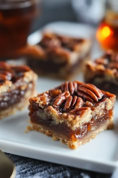 Pecan pie bars with a rich, gooey filling topped with whole pecans on a white plate. Bourbon Pecan Bars Recipe, Chocolate Bourbon Pecan Pie Bars, Chocolate Chip Bourbon Pecan Pie, Bourbon Baking Recipes, Bourbon Recipes Dessert, Maple Bourbon Pecan Pie, Best Bourbon Pecan Pie Recipe, Bourbon Dessert Recipes