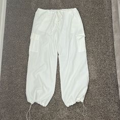 Nwot Never Worn. White Balloon Pants From Cider. Cinch Waist And Cinch Around Ankles. Wide Leg Pants. They Are Pretty See Through. Size Xxs But Run Very Very Big. White Baggy Ankle-length Cargo Pants, White Baggy Parachute Pants For Loungewear, White Baggy Drawstring Pants, Trendy White Sweatpants With Drawstring, Casual White Ankle-length Parachute Pants, White Drawstring Trousers, White Bottoms With Drawstring And Long Pants, White Ankle-length Bottoms With Cargo Pockets, White Summer Sweatpants With Pockets