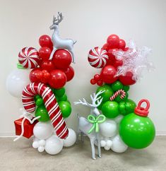 two christmas themed balloons and decorations in the shape of reindeers, trees, and balls