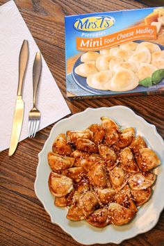 a white plate topped with fried food next to a box of mini donuts and a fork