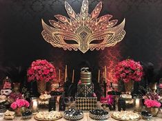 a table topped with lots of black and gold decorations