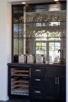 a wine cellar in the corner of a room with glass doors on it's side