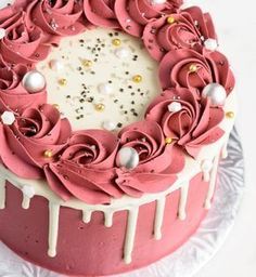 a pink cake with white frosting and flowers on top