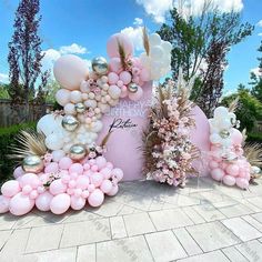 balloons and flowers decorate the entrance to a birthday party