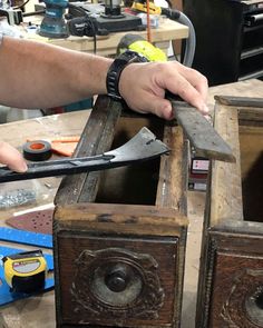 a man is working on an old wooden box with scissors and pliers in it