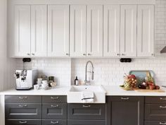 a kitchen with black and white cabinets and counter tops, including a sink in the center