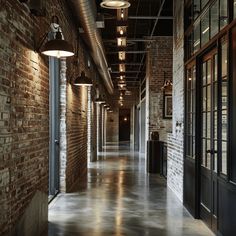 An industrial hallway with exposed brick walls, concrete floors, and metal accents, illuminated by pendant lights hanging from a black metal ceiling4 Bold Artwork, Hallway Design, Feels Like Home, True Colors, You Must, Hallway