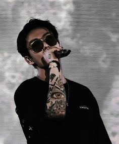 a man with tattoos on his arm holding a microphone