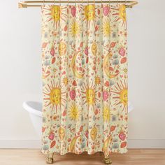 a shower curtain with sun, moon and flowers on it in an orange bathroom setting