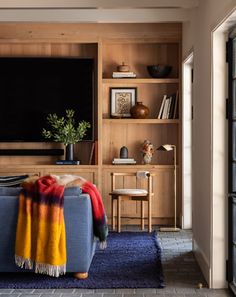 a living room filled with furniture and a flat screen tv mounted on a wall next to a window