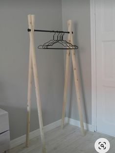 two wooden clothes hangers in front of a gray wall with a white closet door