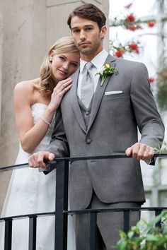 a bride and groom standing on a balcony