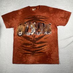 three tigers laying down on top of a brown tie dye t - shirt