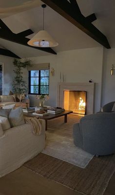 a living room filled with furniture and a fire place in the middle of the room