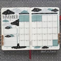 an open planner with clouds and the words november on it, sitting on a black and white patterned surface